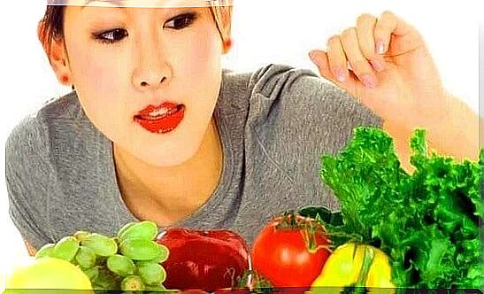 Woman choosing between fruits and vegetables.