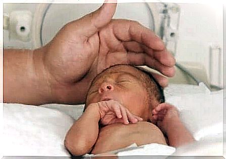 Father taking care of the premature baby in the incubator