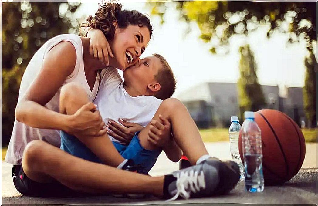 Son kissing his mother after playing basketball, one of the signs that his son loves you.