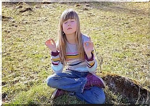 Child meditating outdoors.