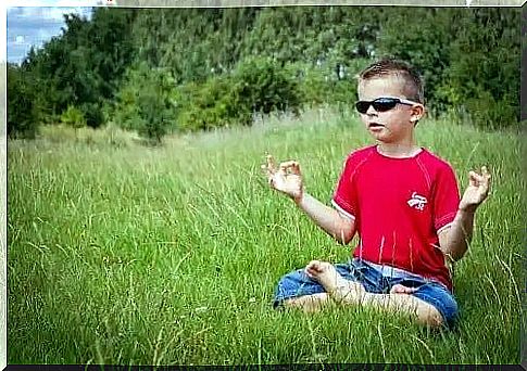 Boy meditating outdoors.