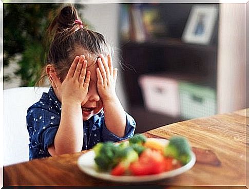 girl with hand on face not wanting to eat vegetables