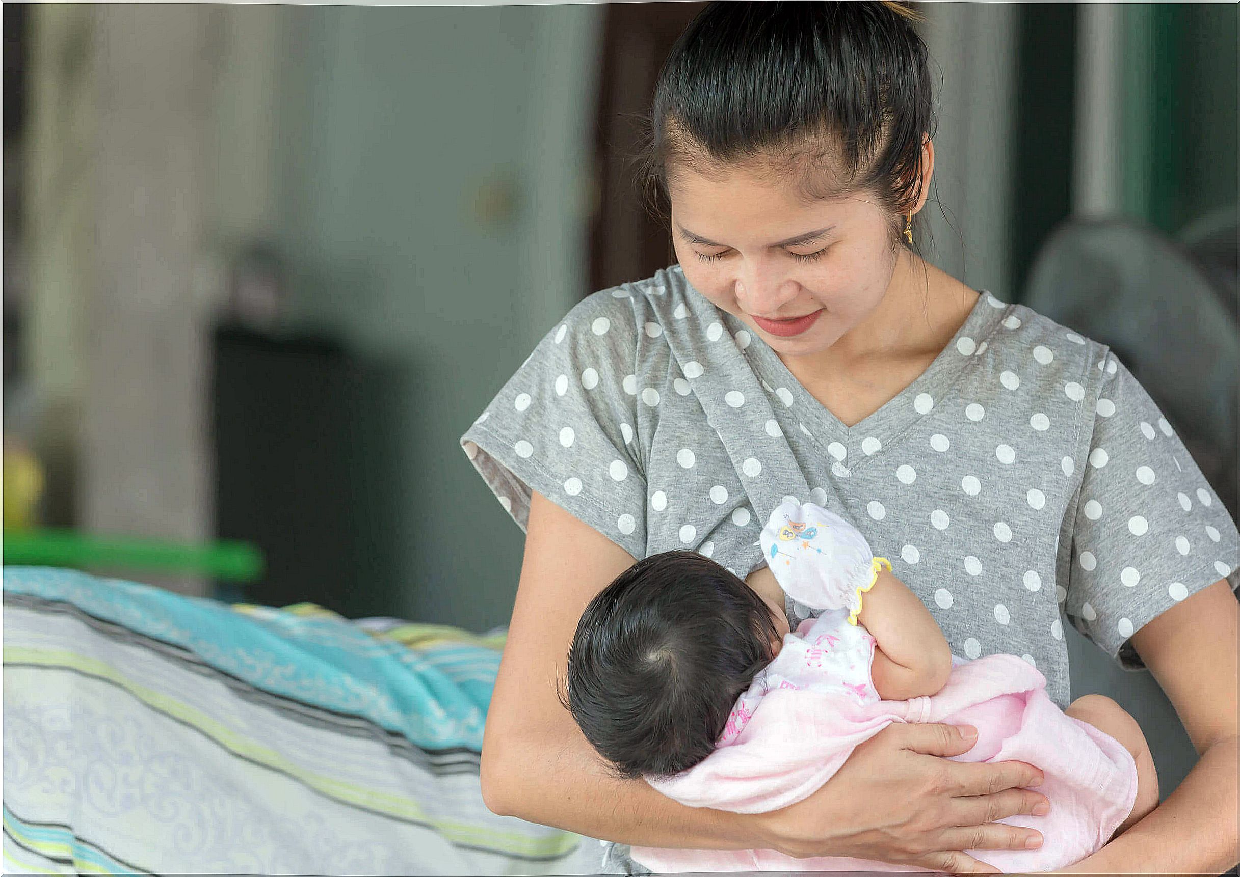 Mother breastfeeding her baby with nipple protectors.